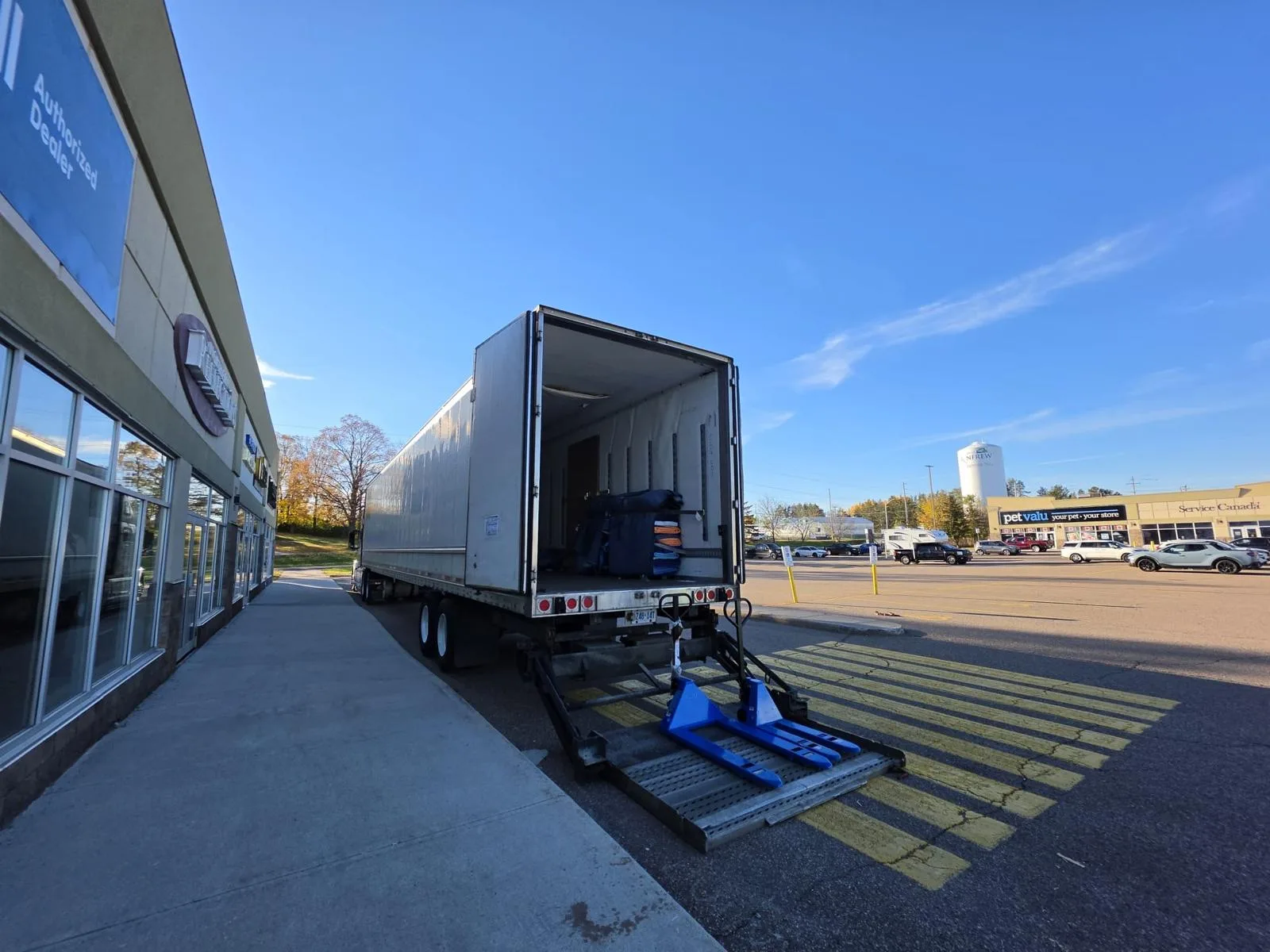 Klacar truck with the liftgate down at a commercial plaza