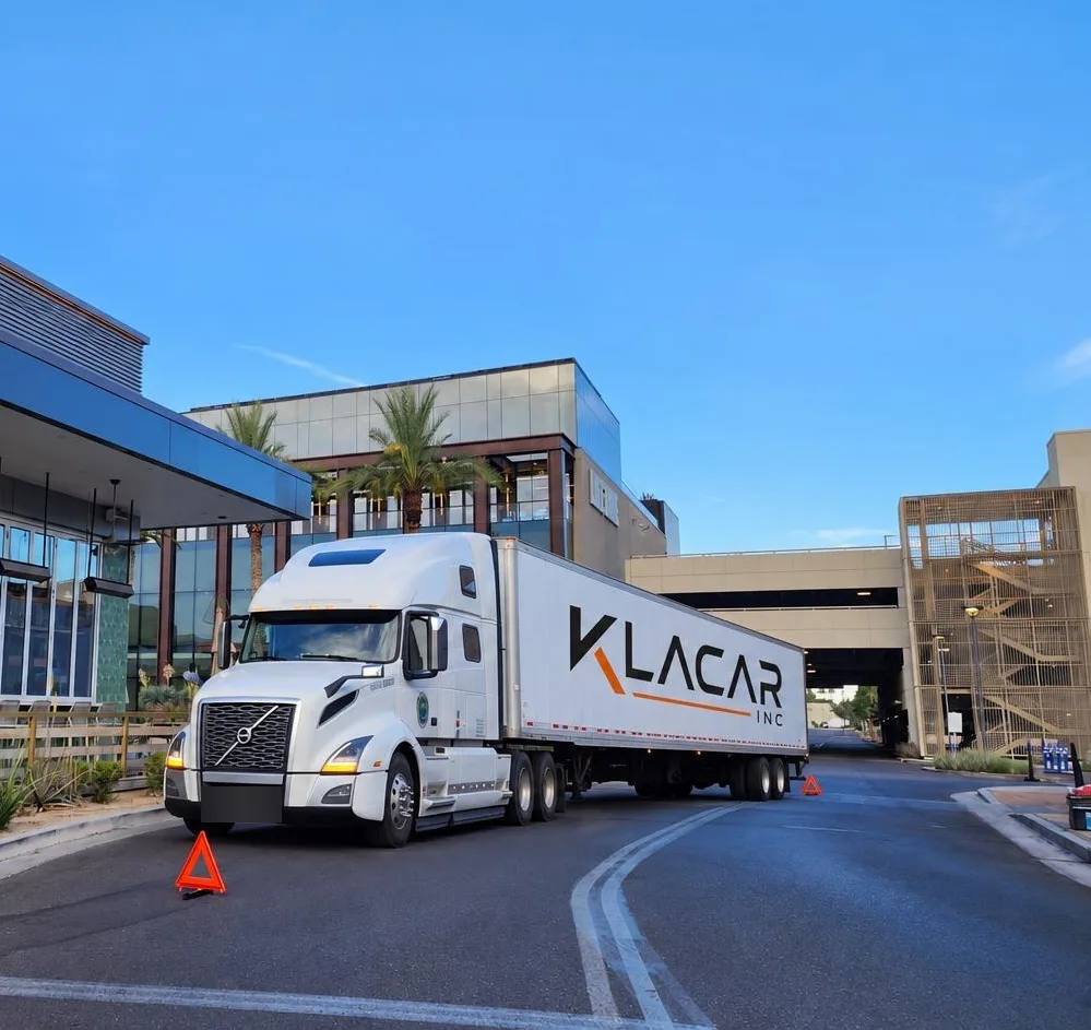 Klacar tractor-trailer parked at a plaza on the road
